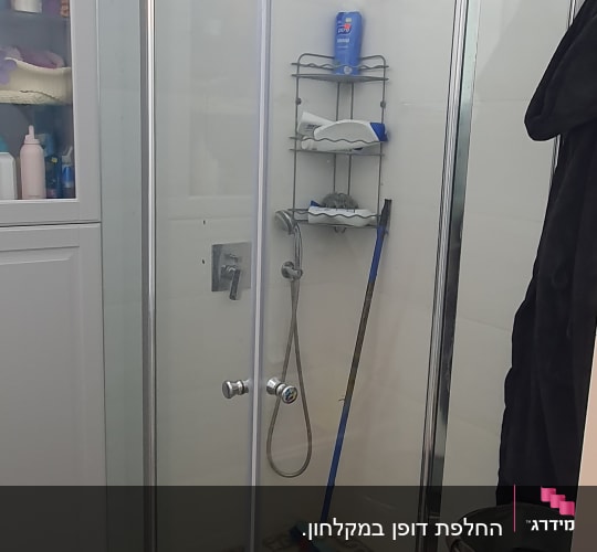 מקלחון זכוכית עם מדף מתכת ומקלחת יד